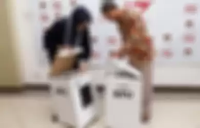 Komisioner KPU Evi Novida Ginting Manik (kiri) dan Pramono Ubaid Tanthowi (kanan), menunjukan kotak suara berbahan dasar karton, di Kantor KPU, Jakarta, Jumat (14/12/2018). 