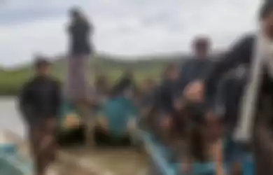 Keturunan wangsa Bonokeling turun dari perahu sampan setelah menziarahi makam leluhur di Adiraja, Jawa Tengah dalam acara adat Mauludan.