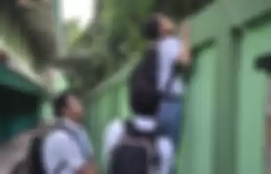 (foto ilustrasi) pelajar SMA memanjat tembok sekolah demi bolos