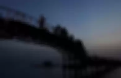 Wisatawan menikmati suasana matahari pagi di Jembatan Cinta.