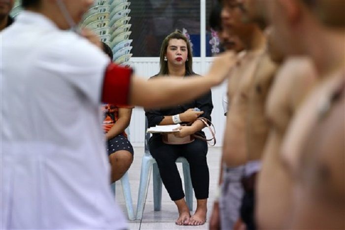 Seorang wanita transgender menunggu pemeriksaan kesehatan selama draf militer di Bangkok, Thailand,