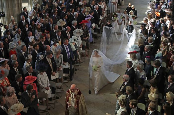 Gaun Meghan Markle dengan aksen long tail