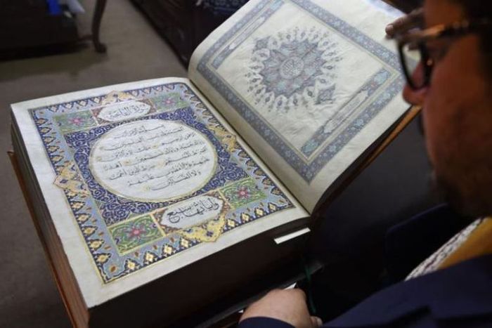 Seniman Afganistan Mohammad Tamim Sahibzada menunjukkan Al Quran buatan tangan yang dibuat dari kain sutra di Turquoise Mountain Foundation, Mourad Khani, di bagian kota tua Kabul, Afghanistan.