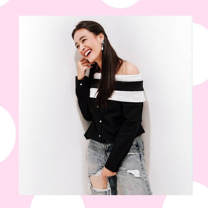 Mawar Eva tampak mengenakan atasan off shoulder bernuansa warna putih dan hitam
