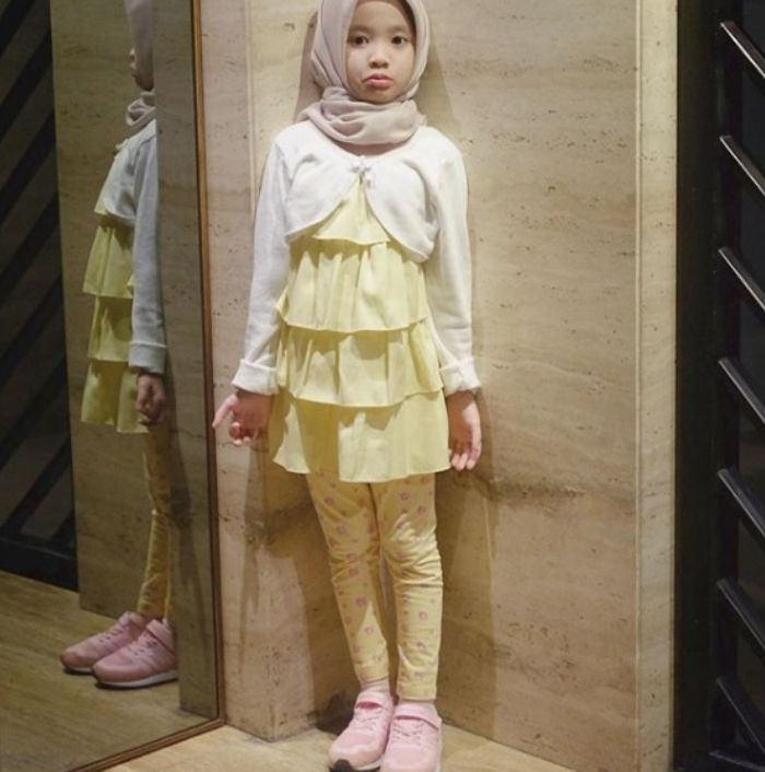Kana Sybilla mengenakan kerudung cokelat muda dengan atasan ruffle berwarna kuning