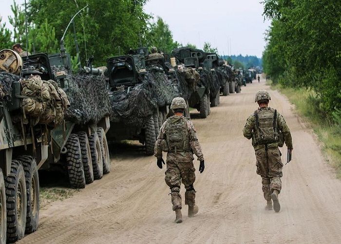 Dua tentara Amerika di samping jejeran AFV Stryker 