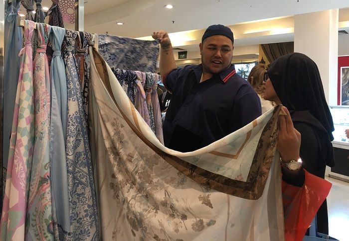 Ivan Gunawan memamerkan hijabnya kepada salah satu calon pembeli