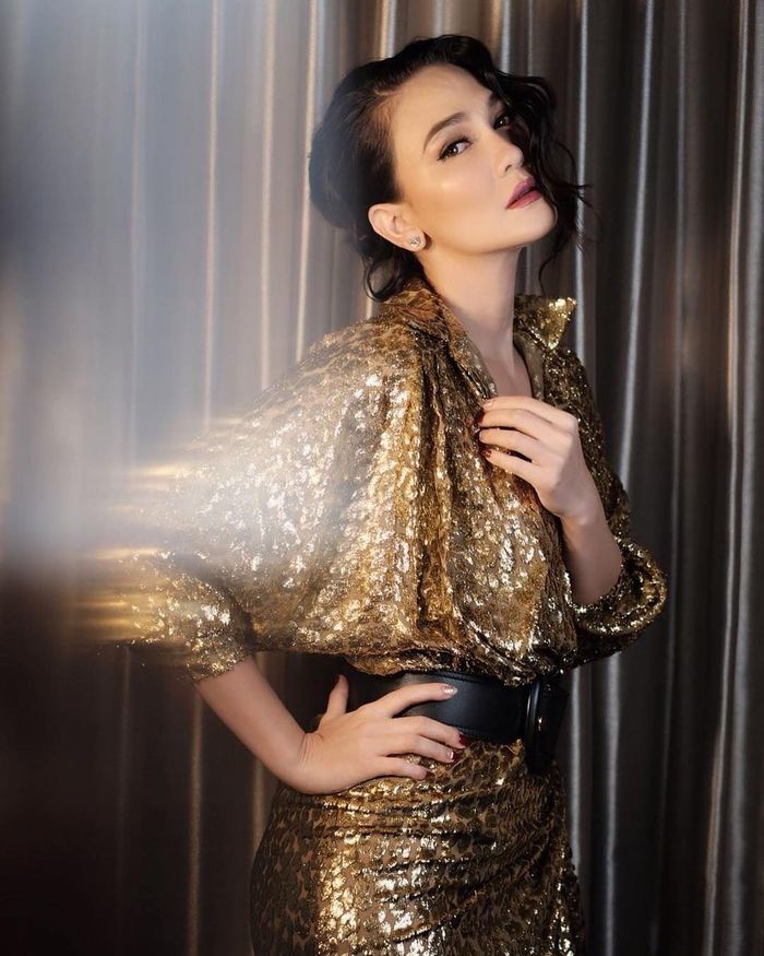 Luna Maya melengkapi penampilan glamornya dengan clutch bag bernuansa senada