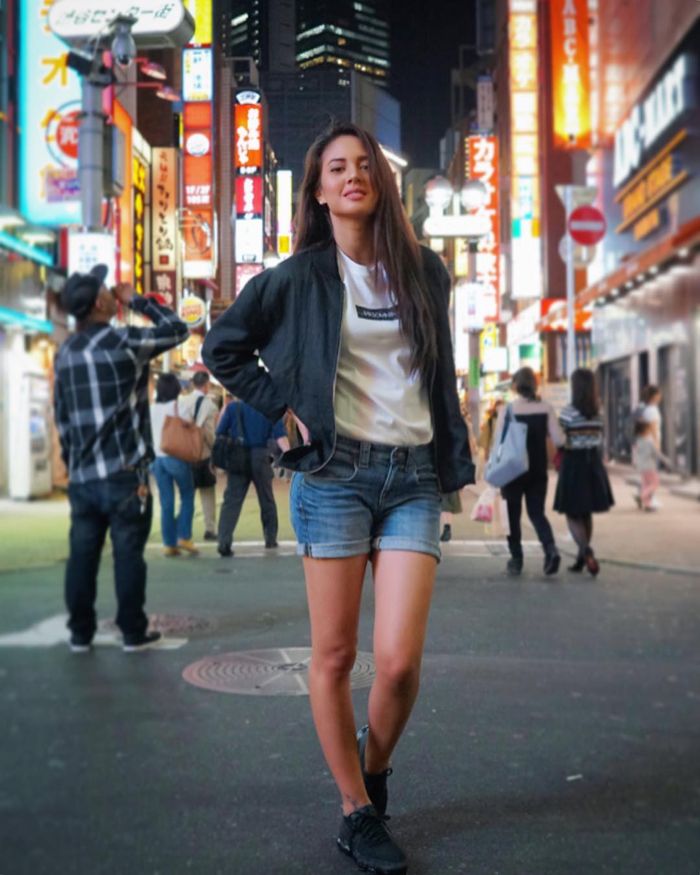 Aurelie Moeremans memadukan rolled up hotpants dengan kaos putih dan jaket bomber