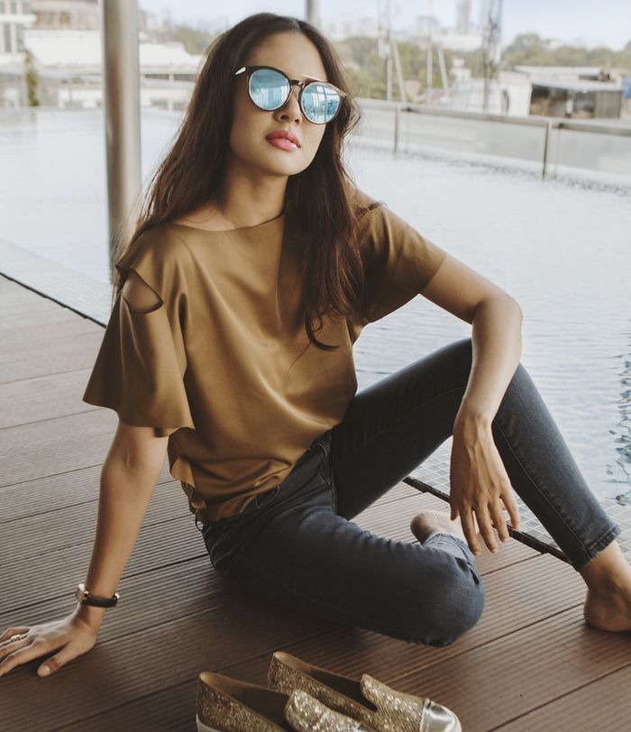 Aurelie dengan atasan cokelat beraksen cut out