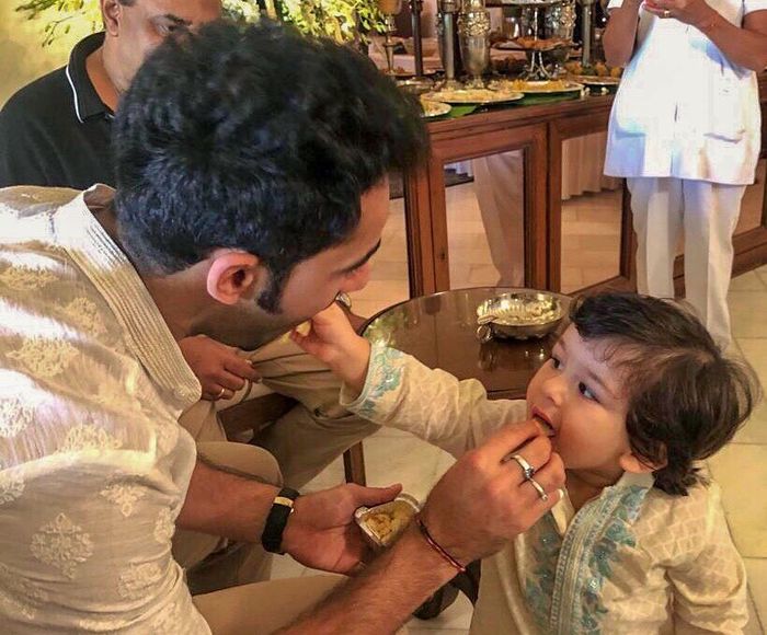 Terlihat Armaan Jain dan Taimur saling menyuap makanan di mulut masing-masing.