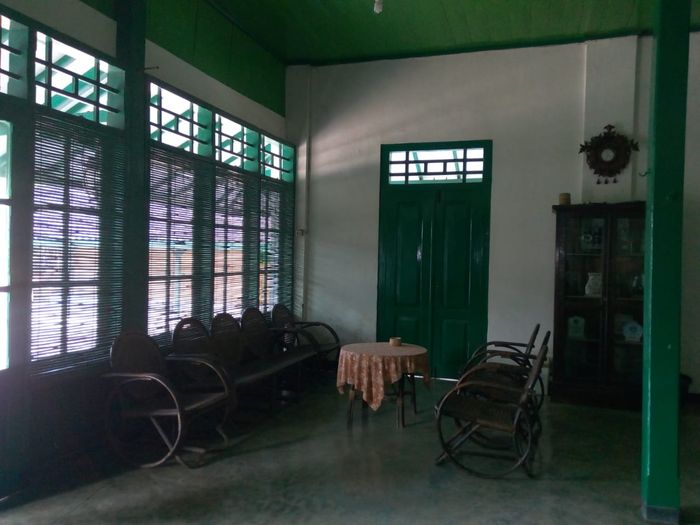 Ruang tamu berisi kursikursi yang masih asli.