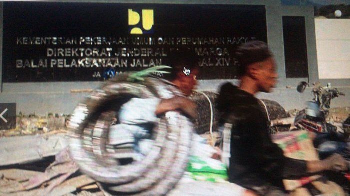 pria berboncengan yang diduga menjarah barang