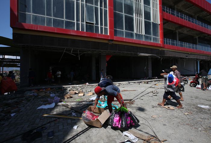 Warga menjarah barang di Grand Palu Mall usai gempa bumi di Pura, Kota Palu, Sulawesi Tengah, Minggu (30/9/2018). Gempa bermagnitudo 7,4 yang mengguncang Donggala dan Palu mengakibatkan ribuan bangunan rusak dan sedikitnya 420 orang meninggal dunia.