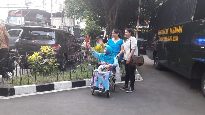 Ibu Roro Fitria melambaikan tangannya melepas kepergian sang putri di persidangan.
