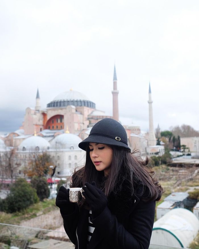 Mila menggunakan topi model Cloche saat berlibur ke luar Negeri