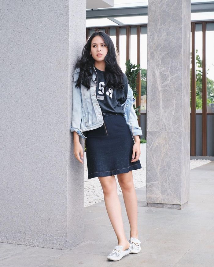 Maudy Ayunda tampak memadukan rok mini berbahan denim dengan t-shirt warna hitam