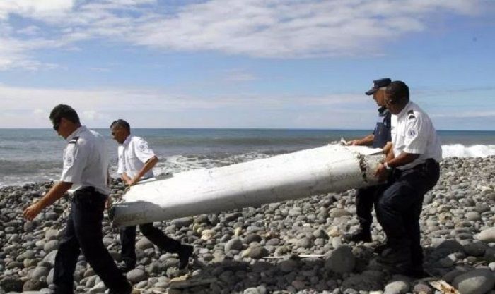 Petugas membawa flaperon dari pesawat terbang yang tampaknya terdampar di Saint-Andre de la Reunion, pulau La Reunion timur, Prancis, pada tahun 2015.