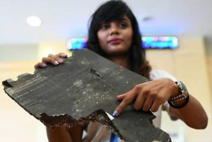 Grace Nathan, salah satu kerabat penumpang penerbangan MH370, menunjukkan serpihan puing yang diyakini milik pesawat yang hilang.