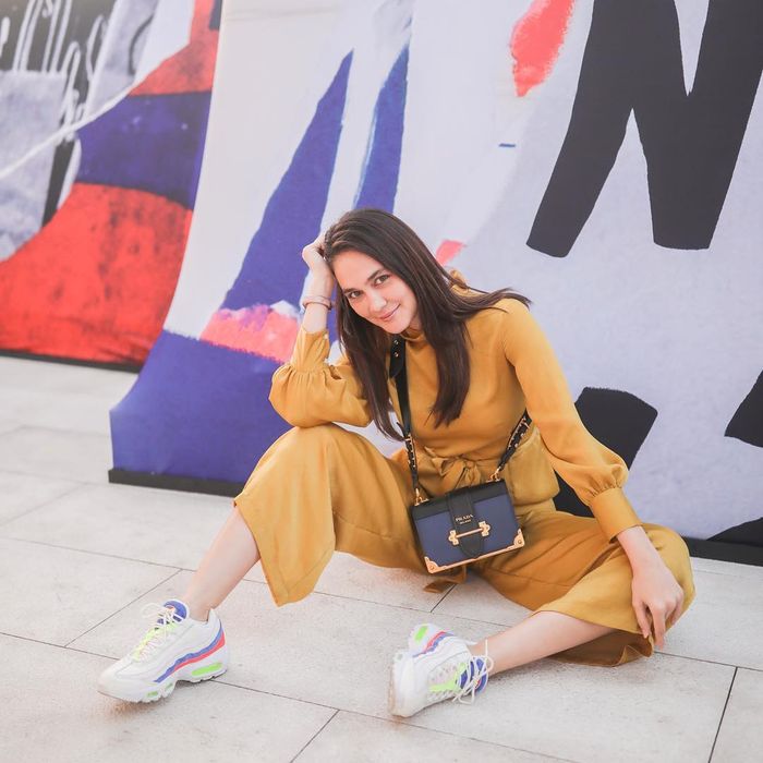 Tampil dengan jumpsuit berwarna kuning mustard dan sneakers putih, siapa takut?