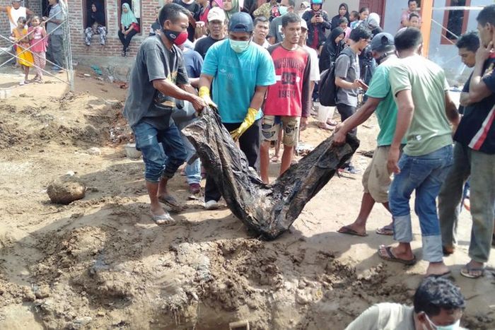 Warga mengangkut jenazah yang ditemukan saat menggali lubang septik tank di lahan pembangunan perumahan bersubsidi, pada Rabu (19/12/2018). Kerangka jenazah ini diyakini sebagai korban bencana gempa dan tsunami yang melanda aceh tahun 2004 lalu.
