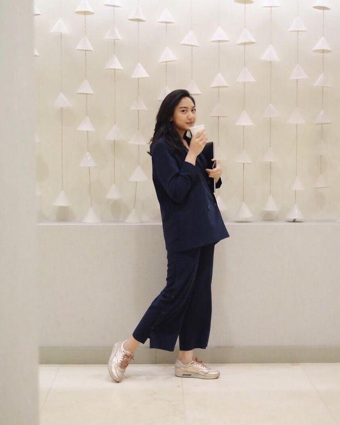 Putri Tanjung yang terlihat elegan dengan setelan kemeja dan celana panjang berwarna navy