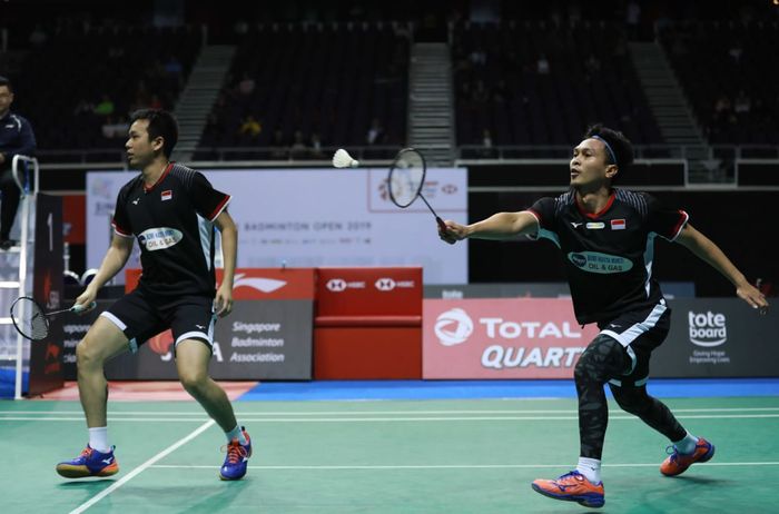 Pasangan ganda putra Indonesia, Mohammad Ahsan/Hendra Setiawan, mengembalikan kok ke arah Li Junhui/Liu Yuchen (China) pada semifinal Malaysia Open 2019 di Singapore Indoor Stadium, Sabtu (13/4/2019).