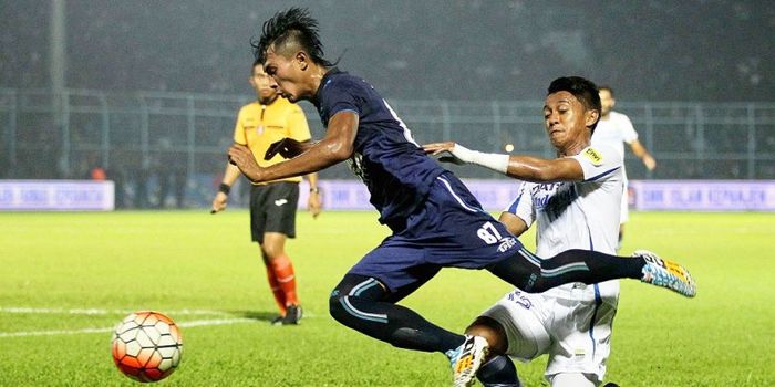 Bek Arema Cronus, Johan Alfarizi (kiri), terjatuh setelah ditekel gelandang Persib Bandung, Febri Ha