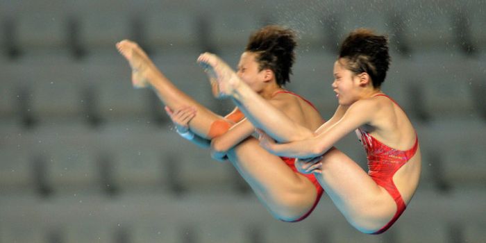 Atlet loncat indah putri Cina Zhang Jiaqi dan Zhang Minjie melakukan loncatan pada final nomor Lonca
