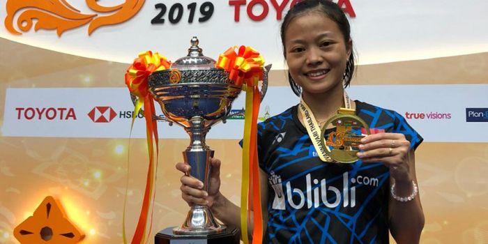 Pebulu tangkis tunggal putri nasional Indonesia, Fitriani, berpose dengan medali dan trofi yang dia 