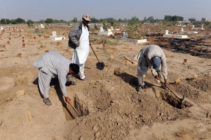 Para sukarelawan menggali kubur untuk bayi-bayi yang ditemukan tak bernyawa