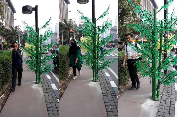 pejalan kaki saat melintas di dekat pohon plastik