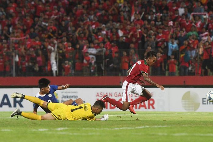 Pesepak bola Indonesia U-16 Mochammad Supriadi (kanan) berusaha melewati penjaga gawang Filipina