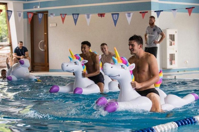 Pemain Timnas Inggris, Harry Maguire (kanan) dan Jesse Lingard lomba naik balon unicorn di kolam ren
