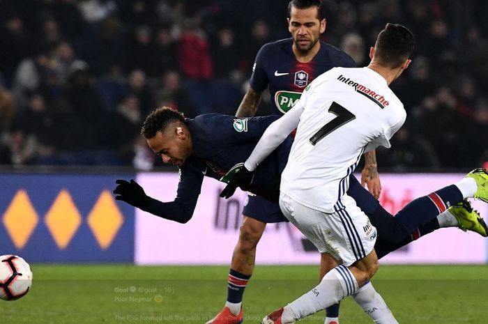 Striker Paris Saint-Germain, Neymar, terjatuh menghindari hadangan pemain Strasbourg, Moataz Zemzemi
