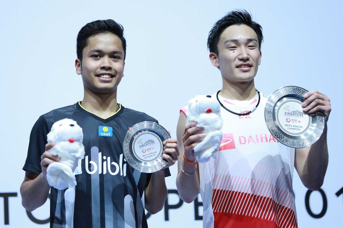 Juara tunggal putra Singapore Open 2019 asal Jepang, Kento Momota (kanan), berpose dengan sang runner-up dari Indonesia, Anthony Sinisuka Ginting.