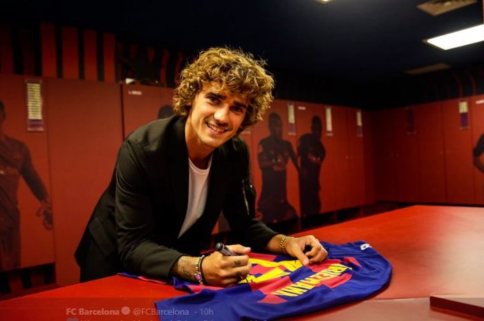 Antoine Griezmann menandatangani seragam anyarnya di FC Barcelona.