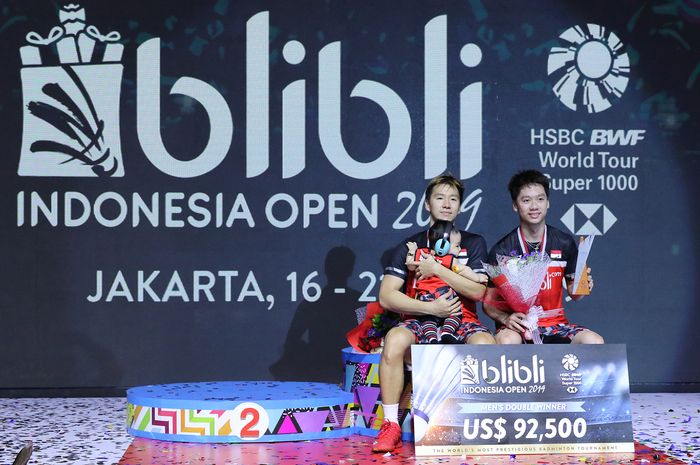 Pasangan ganda putra Indonesia, Marcus Fernaldi Gideon/Kevin Sanjaya Sukamuljo, berpose di podium juara Indonesia Open 2019 di Istora Senayan, Jakarta, Minggu (21/7/2019)