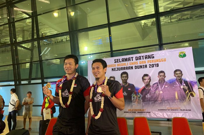 Pasangan juara dunia asal Indonesia, Hendra Setiawan (kiri) dan Mohammad Ahsan, berpose dengan medali emas mereka pada konferensi pers di Terminal 3 Bandara Soekarno-Hatta, Banten, Jawa Barat, Selasa (27/8/2019).
