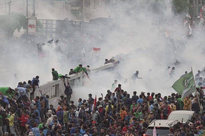 Gas air mata dilontarkan polisi saat demo ricuh di depan gedung DPR, Selasa (24/9).