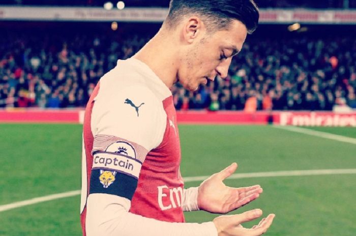 Pemain Arsenal, Mesut Oezil berdoa.