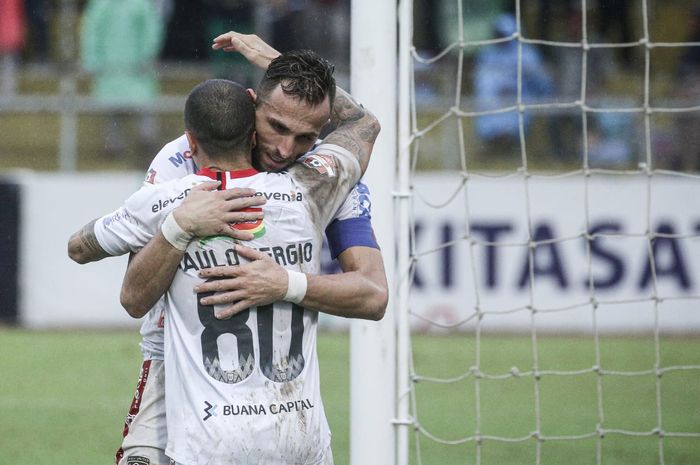 Striker Bali United, Ilija Spasojevic, mendapatkan pelukan dari Paulo Sergio seusai mencetak gol ke gawang Semen Padang pada pekan ke-30 Liga 1 2019.