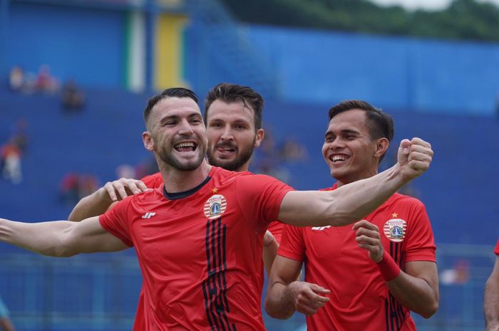 Marko Simic merayakan golnya ke gawang Persela Lamongan bersama Marco Motta dan Rezaldi Hehanussa, di Stadion Kanjuruhan, Malang.