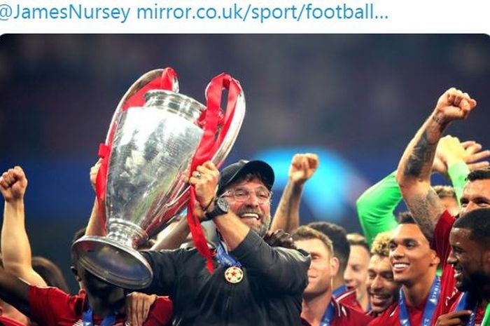 Pelatih Liverpool, Juergen Klopp, mengangkat trofi Liga Champions.