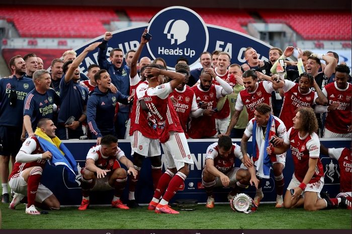 Striker Arsenal, Pierre-Emerick Aubameyang, menjatuhkan trofi saat selebrasi juara Piala FA.