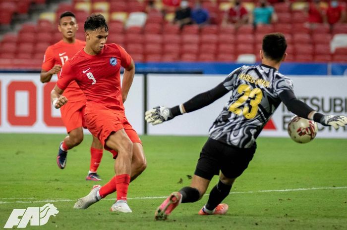 Striker timnas Singapura, Ikhsan Fandi, saat mengelabuhi kiper timnas Indonesia Nadeo Argawinata pada leg pertama semifinal Piala AFF 2020.