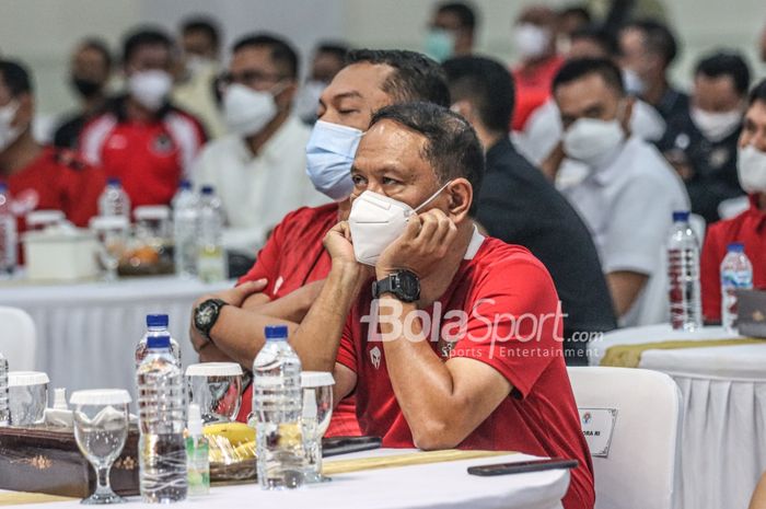 Menteri Pemuda dan Olahraga Republik Indonesia, Zainudin Amali (kanan), nampak serius mengamati pertandingan leg pertama Final Piala AFF 2020 dalam acara nonton bareng di  Kantor Kemenpora, Senayan, Jakarta, 29 Desember 2021.