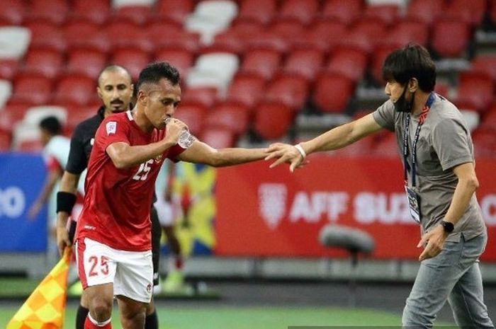 Pelatih Indonesia, Shin Tae-yong (kanan), menyalaman Irfan Jaya setelah mencetak gol kedua dalam pertandingan Piala AFF 2020 antara Malaysia vs Indonesia di Stadion Nasional, Singapura, pada Minggu (19/12/20201). 