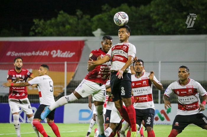 Pemain Madura United saat berusaha mengamankan bola dari pemain Bali United dalam laga pekan ke-32 Liga 1 2021/2022, di Stadion Kompyang Sujana, Denpasar, Bali, Senin (21/3/2022).