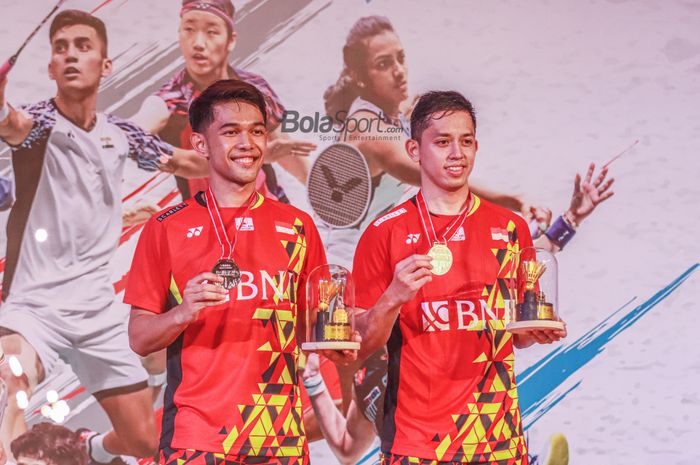 Atlet bulu tangkis ganda putra Indonesia, Fajar Alfian dan Muhammad Rian Ardianto, sedang pamer medali juara satu di Indonesia Masters 2022.